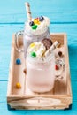 Fresh strawberry and blueberry milkshakes on blue table.