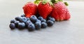 Fresh strawberry and blueberry mix on a metal dish over a rough rustic wood background Royalty Free Stock Photo