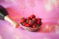 Fresh strawberry, bottle of champagne and glasses of champagne. Selective focus on strawberry