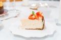Fresh strawberry cheesecake on a ceramic plate on a white festive table Royalty Free Stock Photo