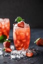 Fresh strawberry cocktail. Fresh summer cocktail with strawberry and ice cubes. Glass of strawberry soda drink on dark background. Royalty Free Stock Photo