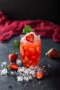 Fresh strawberry cocktail. Fresh summer cocktail with strawberry and ice cubes. Glass of strawberry soda drink on dark background. Royalty Free Stock Photo