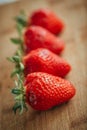 Fresh strawberry on a dark wood background, close up of big strawberry on wood