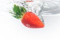 Fresh strawberry dropped into clear water with splash isolated on white background