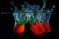 fresh strawberry dropped into water with splash on black backgrounds Royalty Free Stock Photo