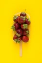 Fresh strawberry for ice cream on painted popsicle shape over yellow background. Top view. Copy space. Organic fruit. Food Royalty Free Stock Photo