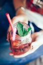 Fresh strawberry lemonade in the hands of a girl in a cafe