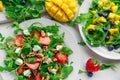 Fresh strawberry, mango, blueberrie salad with feta cheese, arugula on white plate Royalty Free Stock Photo