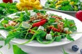 Fresh strawberry, mango, blueberrie salad with feta cheese, arugula on white plate