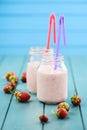 Fresh strawberry milk cocktail in mason jars with straws on blue Royalty Free Stock Photo