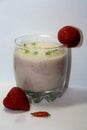 Fresh strawberry milk shake in a glass with red spicy pepper. Black and white focus. Bubbles and green