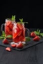 Fresh strawberry smoothie. Fresh summer cocktail with strawberries and ice cubes on a dark background on a black wooden table Royalty Free Stock Photo