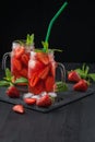 Fresh strawberry smoothie. Fresh summer cocktail with strawberries and ice cubes on a dark background on a black wooden table Royalty Free Stock Photo