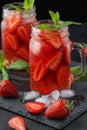 Fresh strawberry smoothie. Fresh summer cocktail with strawberries and ice cubes on a dark background on a black wooden table Royalty Free Stock Photo