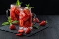 Fresh strawberry smoothie. Fresh summer cocktail with strawberries and ice cubes on a dark background on a black wooden table Royalty Free Stock Photo