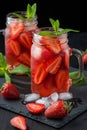 Fresh strawberry smoothie. Fresh summer cocktail with strawberries and ice cubes on a dark background on a black wooden table Royalty Free Stock Photo