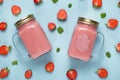 Fresh strawberry smoothie in the two mason jars on blue background. Royalty Free Stock Photo