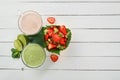 Fresh strawberry smoothies and vegetable green smoothies with lime and mint near a fruit salad of strawberries, kiwi Royalty Free Stock Photo