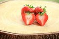 Fresh strawberry, sweet fruits, whole and cut in half, on the wooden chopping board. Royalty Free Stock Photo