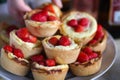 Fresh strawberry-topped cupcakes on rustic table Royalty Free Stock Photo
