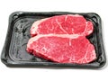 Fresh strip loin steak on a black plastic tray and on white background. Meat industry product. Top quality meat with excellent