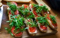 Fresh submarine baguette sandwich with ham, cheese, tomatoes and wild rocket. Selective focus Royalty Free Stock Photo