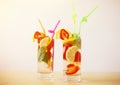 Fresh summer drinks with lemon, strawberry and mint on the wooden table