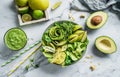 Fresh summer salad with avocado, kiwi, apple, cucumber, pear, micro greens, lime and sesame with smoothie on light marble Royalty Free Stock Photo