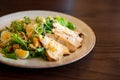 Fresh summer salad Ceasar with eggs, lettuce, chicken and parmesan cheese on white plate on wooden background; healthy concept; si Royalty Free Stock Photo