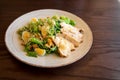 Fresh summer salad Ceasar with eggs, lettuce, chicken and parmesan cheese on white plate on wooden background; healthy concept; si Royalty Free Stock Photo