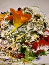 Fresh summer salad with edible flowers nasturtium, borage flowers in a bowl. Top view Royalty Free Stock Photo