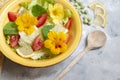 Fresh summer salad with nasturtium flowers,tomatoes and lemones in yellow ceramic bowl Royalty Free Stock Photo