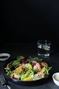 Fresh summer salad with shrimps, mix of green leaves and sesame seeds on a dark background, side view, copy space. Royalty Free Stock Photo