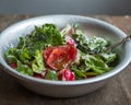 Fresh summer salad of tomatoes, cucumbers and aromatic herbs, dressed with sour cream in a deep aluminum bowl with a spoon, on an Royalty Free Stock Photo