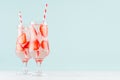 Fresh summer strawberry lemonade with ripe berry pieces, ice cubes, tonic, straw in light soft pastel blue color background. Royalty Free Stock Photo