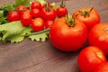 Fresh summer tomatoes and greens on rustic table Royalty Free Stock Photo