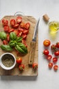 Fresh summer tomatoes, leaves of green basil, and olive oil