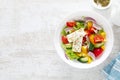 Fresh summer vegetable salad with lettuce, tomato, cucumber, bell pepper, onion and feta cheese, dressed with olive oil Royalty Free Stock Photo