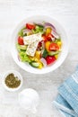 Fresh summer vegetable salad with lettuce, tomato, cucumber, bell pepper, onion and feta cheese, dressed with olive oil Royalty Free Stock Photo