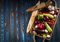 Fresh summer vegetables and two baguettes on a tray on a blue wooden background.