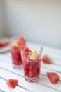 Fresh summer watermelon drink in a glass glass and a piece of watermelon on a wooden board. Vertical photo orientation Royalty Free Stock Photo