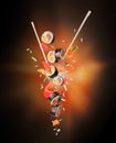 Fresh sushi rolls with chopsticks frozen in the air on a black background Royalty Free Stock Photo