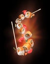 Fresh sushi rolls with ginger frozen in the air on black background Royalty Free Stock Photo