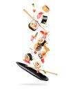 Fresh sushi rolls with various ingredients falling on a black clay plate