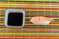 Fresh sushi with shrimp nigiri next to soy sauce on a natural bamboo mat Royalty Free Stock Photo