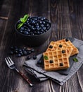 Fresh sweet blueberry with aromatic belgian waffels and honey dark wood table