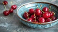 Fresh sweet cherries bowl with leaves in water drops on blue stone background, top view Royalty Free Stock Photo