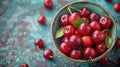 Fresh sweet cherries bowl with leaves in water drops on blue stone background, top view Royalty Free Stock Photo