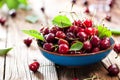 Fresh sweet cherries bowl with leaves in water drops on wooden b Royalty Free Stock Photo