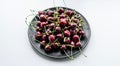 Fresh sweet cherries plate with leaves in water drops on stone background, top view